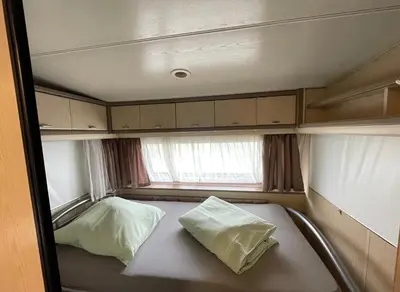 Ein Bett oder Betten in einem Zimmer der Unterkunft Campingplatz Wohnwagen mit Vorzelt