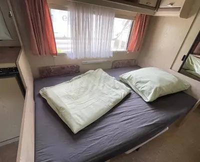 Ein Bett oder Betten in einem Zimmer der Unterkunft Campingplatz Wohnwagen mit Vorzelt
