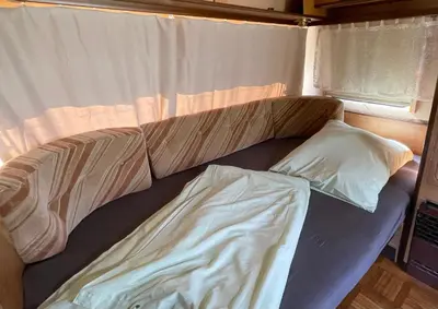 Ein Bett oder Betten in einem Zimmer der Unterkunft Wohnwagen mit Vorzelt auf einem Campingplatz