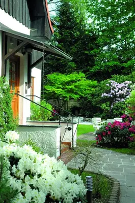 Ein Garten an der Unterkunft Hotel Alpenhof - ruhige Wohlfühloase zwischen München, dem Fünf-Seenland und den Bergen, in S-Bahnnähe