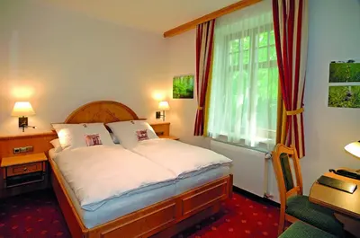 Ein Bett oder Betten in einem Zimmer der Unterkunft Hotel Alpenhof - ruhige Wohlfühloase zwischen München, dem Fünf-Seenland und den Bergen, in S-Bahnnähe