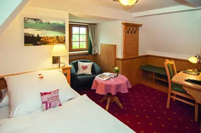 Ein Bett oder Betten in einem Zimmer der Unterkunft Hotel Alpenhof - ruhige Wohlfühloase zwischen München, dem Fünf-Seenland und den Bergen, in S-Bahnnähe