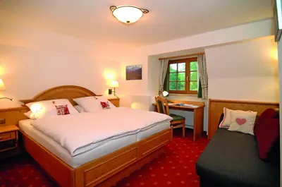 Ein Bett oder Betten in einem Zimmer der Unterkunft Hotel Alpenhof - ruhige Wohlfühloase zwischen München, dem Fünf-Seenland und den Bergen, in S-Bahnnähe