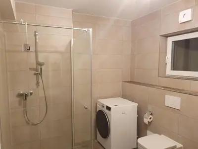 Ein Badezimmer in der Unterkunft 75m2 lichtdurchflutete 3 Zimmer Souterrain Wohnung in einem Neubau Villa