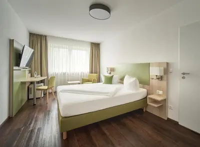 Ein Bett oder Betten in einem Zimmer der Unterkunft Marias Inn Hotel & Apartments Garching bei München