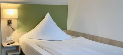 Ein Bett oder Betten in einem Zimmer der Unterkunft Marias Inn Hotel & Apartments Garching bei München