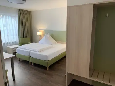 Ein Bett oder Betten in einem Zimmer der Unterkunft Marias Inn Hotel & Apartments Garching bei München