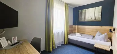 Ein Bett oder Betten in einem Zimmer der Unterkunft ARRIVEL Pension Pliening - bisher Novitel