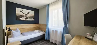 Ein Bett oder Betten in einem Zimmer der Unterkunft ARRIVEL Pension Pliening - bisher Novitel