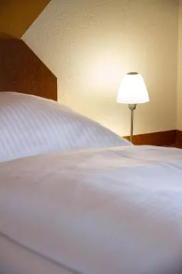 Ein Bett oder Betten in einem Zimmer der Unterkunft Hotel Garni Haus zum Gutenberg