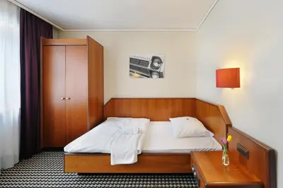 Ein Bett oder Betten in einem Zimmer der Unterkunft Ambassador Parkhotel