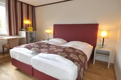 Ein Bett oder Betten in einem Zimmer der Unterkunft Ambassador Parkhotel