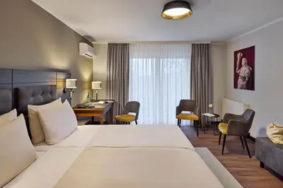 Ein Bett oder Betten in einem Zimmer der Unterkunft Dorint MARC AUREL Spa & Golf Resort