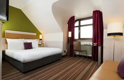 Ein Bett oder Betten in einem Zimmer der Unterkunft Leonardo Hotel & Residenz Muenchen
