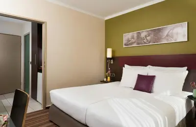 Ein Bett oder Betten in einem Zimmer der Unterkunft Leonardo Hotel & Residenz Muenchen
