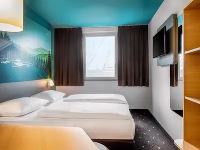 Ein Bett oder Betten in einem Zimmer der Unterkunft B&B Hotel München-Putzbrunn