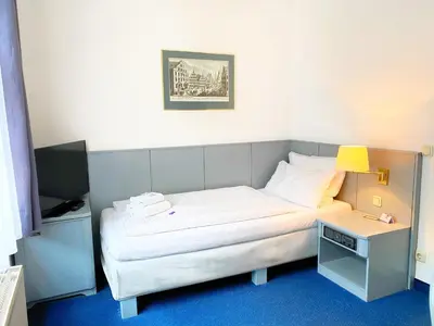 Ein Bett oder Betten in einem Zimmer der Unterkunft Altstadthotel Augsburg