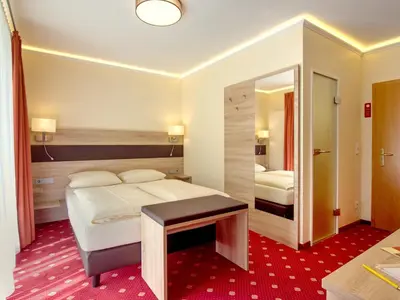 Ein Bett oder Betten in einem Zimmer der Unterkunft Hotel Kriemhild am Hirschgarten