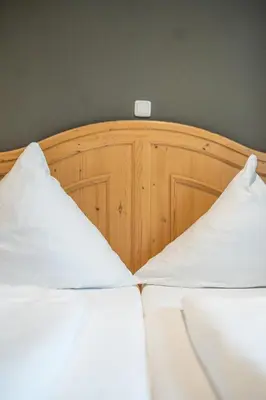 Ein Bett oder Betten in einem Zimmer der Unterkunft Tegernseer Hof