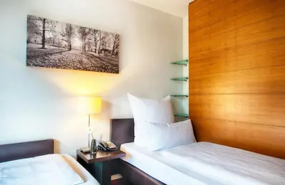 Ein Bett oder Betten in einem Zimmer der Unterkunft Leonardo Hotel Muenchen City West
