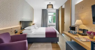 Ein Bett oder Betten in einem Zimmer der Unterkunft Alpen Hotel München
