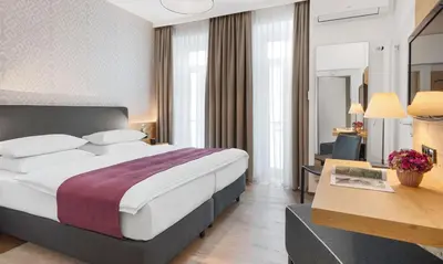 Ein Bett oder Betten in einem Zimmer der Unterkunft Alpen Hotel München