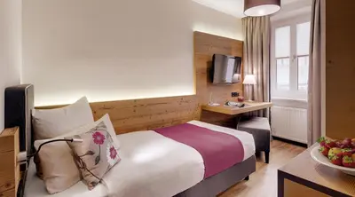 Ein Bett oder Betten in einem Zimmer der Unterkunft Alpen Hotel München