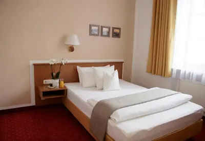 Ein Bett oder Betten in einem Zimmer der Unterkunft Stadthotel Erding