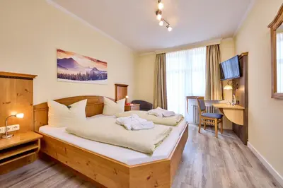 Ein Bett oder Betten in einem Zimmer der Unterkunft Hotel Vier Jahreszeiten