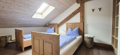 Ein Bett oder Betten in einem Zimmer der Unterkunft Baumgartner Nagerhof | Chiemgau Karte