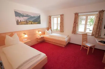 Ein Bett oder Betten in einem Zimmer der Unterkunft Pension Schweizerhaus Garni