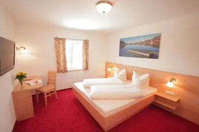 Ein Bett oder Betten in einem Zimmer der Unterkunft Pension Schweizerhaus Garni