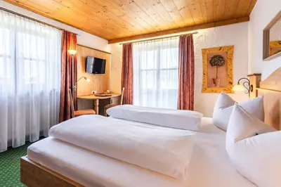 Ein Bett oder Betten in einem Zimmer der Unterkunft Das Maximilian - Feines Landhotel am Schliersee