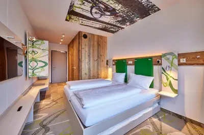 Ein Bett oder Betten in einem Zimmer der Unterkunft Explorer Hotel Garmisch