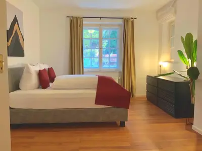 Ein Bett oder Betten in einem Zimmer der Unterkunft Edle Altbauwohnung trifft oberbayrisches Bergidyll